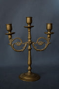 Drie-armige messing kandelaar met florale ornamenten