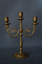 Drie-armige messing kandelaar met florale ornamenten