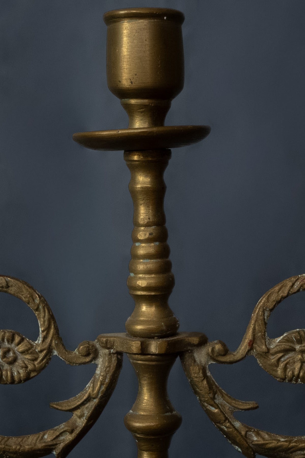 Drie-armige messing kandelaar met florale ornamenten